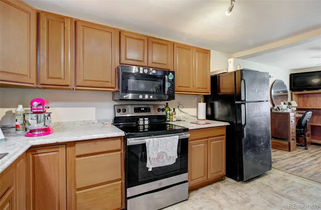 a kitchen with stainless steel appliances granite countertop a stove refrigerator sink and microwave