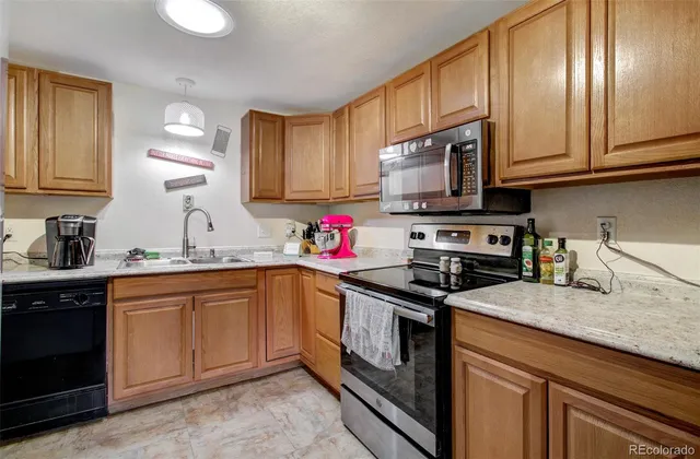 a kitchen with granite countertop stainless steel appliances sink stove microwave and cabinets