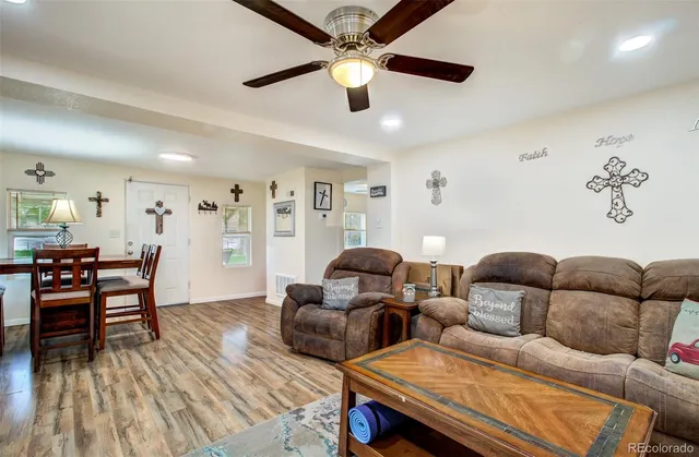 a living room with furniture and a wooden floor
