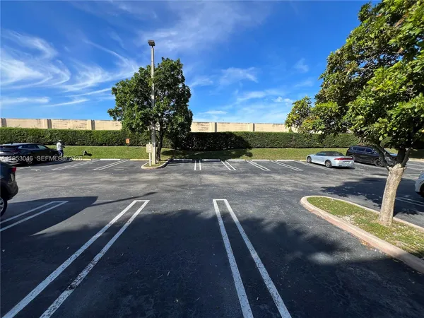 a view of a tennis ground with large trees