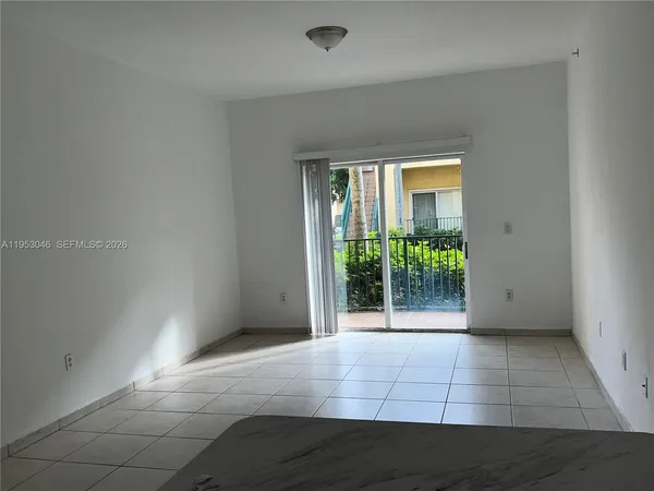 a view of an empty room with wooden floor and a porch