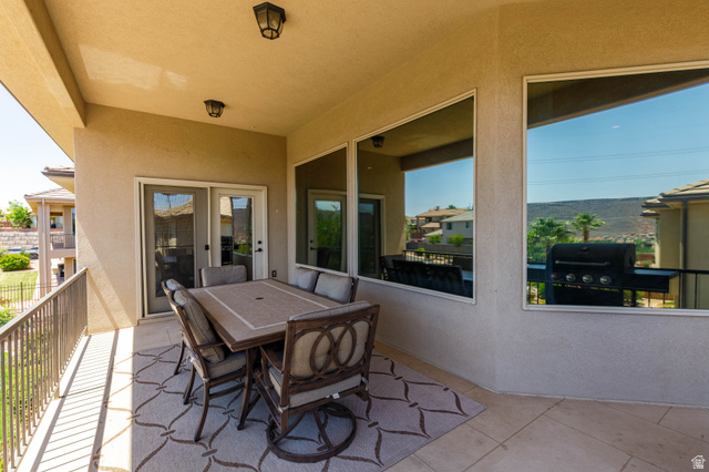 2005 West 450 S Circle St. George, UT 84770 - Photo 13 of 57 Covered patio featuring a stucco ceiling with two flush-mount light fixtures, stucco walls, and tile flooring