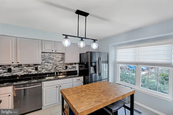 a kitchen with stainless steel appliances granite countertop a stove a refrigerator a kitchen island a sink dishwasher and a refrigerator