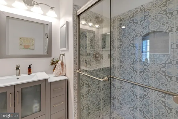 a bathroom with a sink mirror and a shower