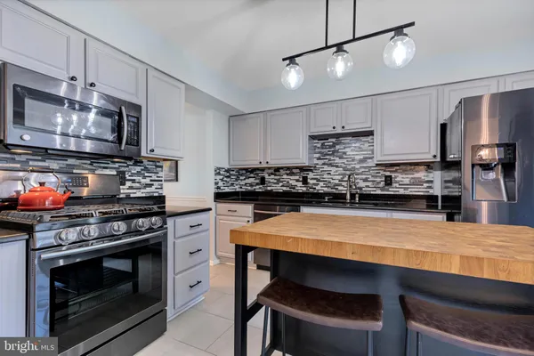 a kitchen with stainless steel appliances a stove microwave and refrigerator