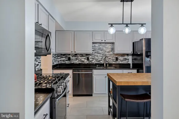 a kitchen with stainless steel appliances granite countertop a stove a sink and a refrigerator
