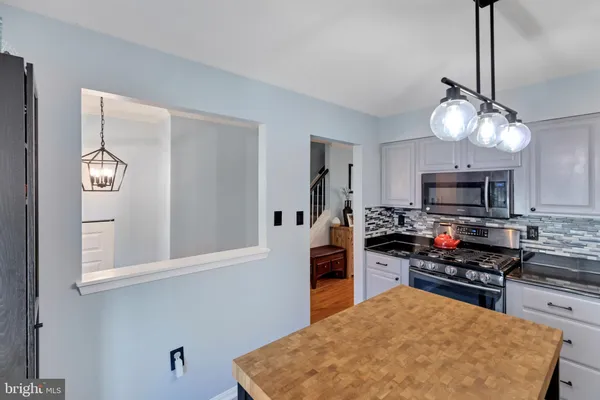 a kitchen with stainless steel appliances granite countertop a sink a stove and a refrigerator