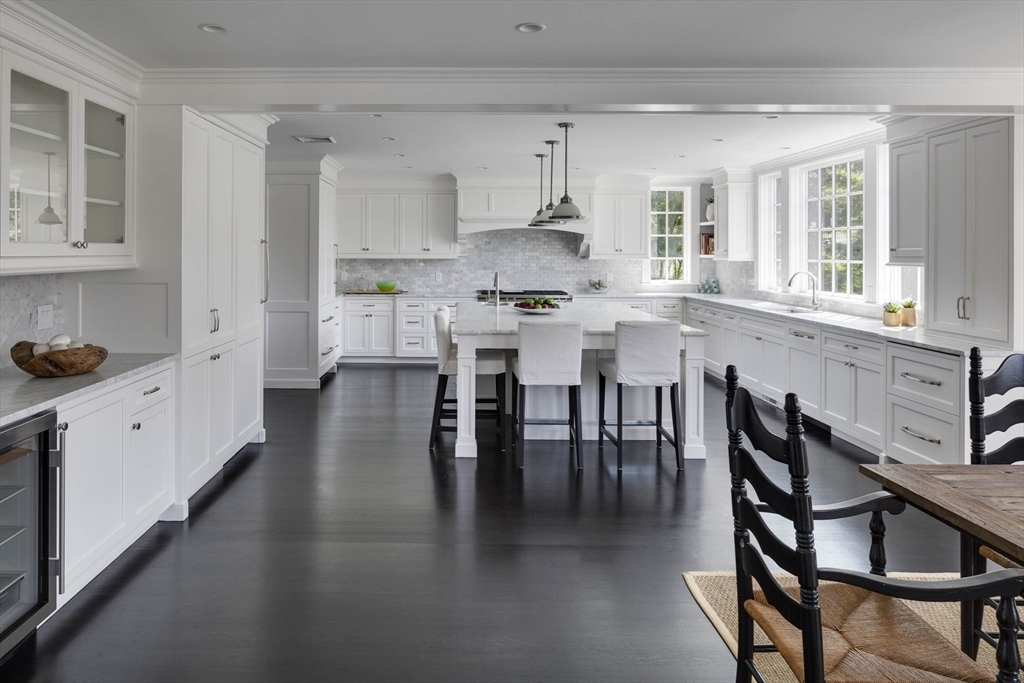 1 Adams Street Lexington, MA 02420 - Photo 4 of 20 a kitchen with stainless steel appliances granite countertop a table chairs and a refrigerator