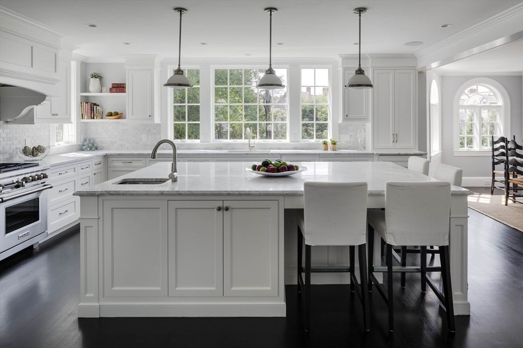 1 Adams Street Lexington, MA 02420 - Photo 5 of 20 a kitchen with stainless steel appliances granite countertop a sink a stove a dining table and chairs