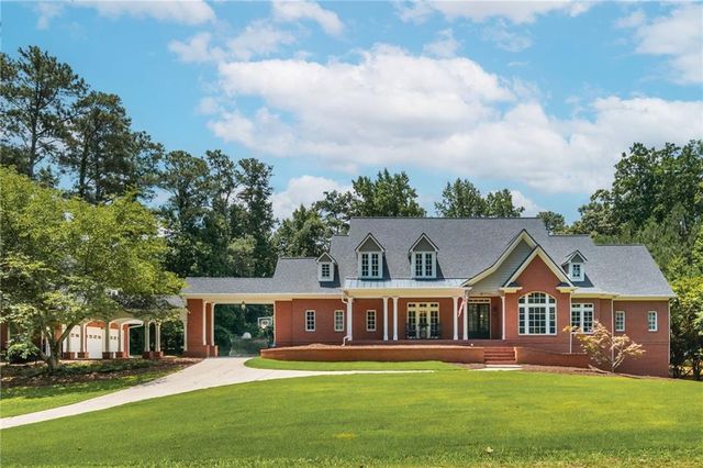 a front view of a house with a garden and trees