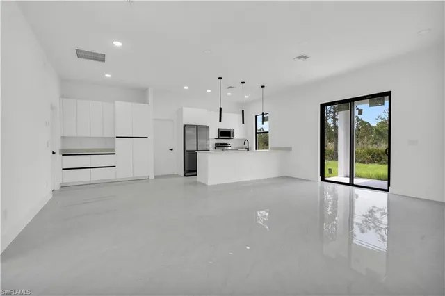 a view of a kitchen with refrigerator and windows