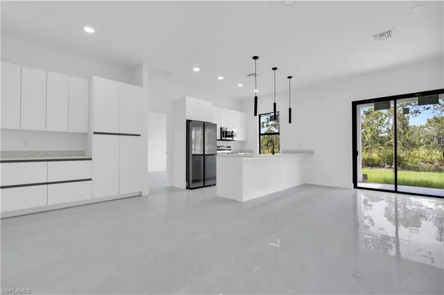 a view of a kitchen with refrigerator and a sink
