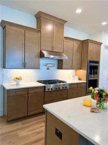 a kitchen with stainless steel appliances a stove a microwave and a refrigerator