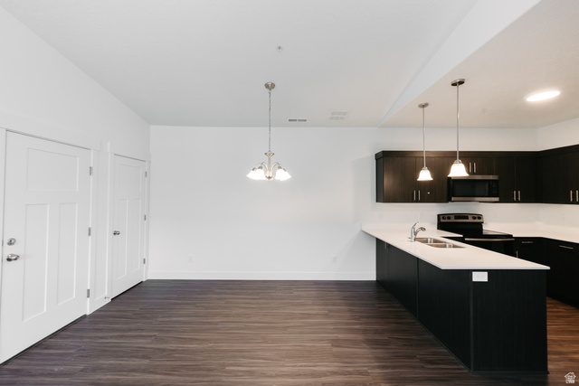 4655 South 720 West, Unit I303 Mapleton, UT 84664 - Photo 13 of 15 Kitchen featuring a peninsula, hanging lights, dark wood-style flooring, dark cabinetry, and stainless steel microwave