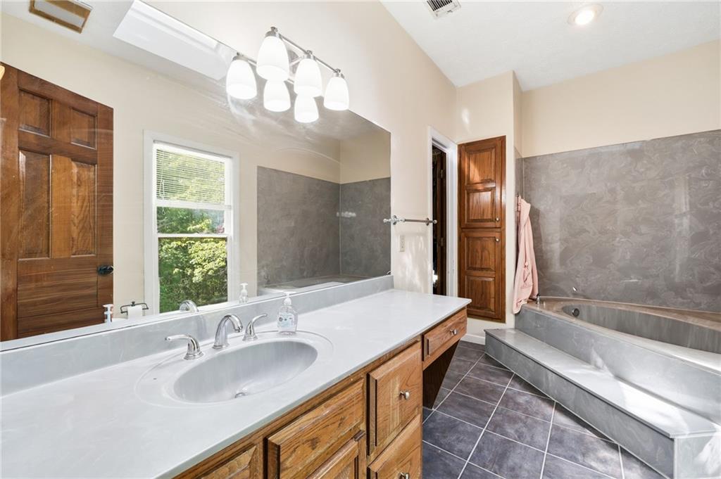 2737 John Petree Road Powder Springs, GA 30127 - Photo 25 of 55 a bathroom with a tub sink and mirror