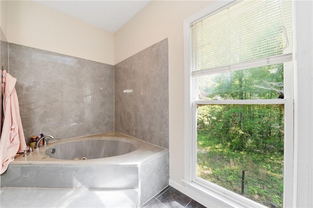 2737 John Petree Road Powder Springs, GA 30127 - Photo 26 of 55 a bath tub sitting in a bathroom next to a window