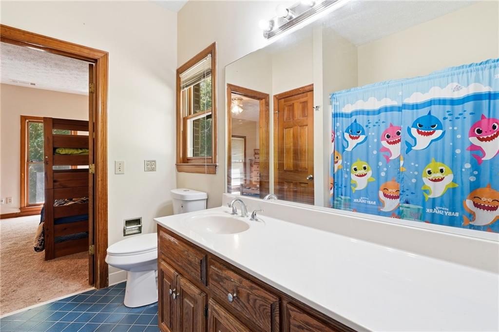 2737 John Petree Road Powder Springs, GA 30127 - Photo 30 of 55 a bathroom with a sink a toilet and a large mirror
