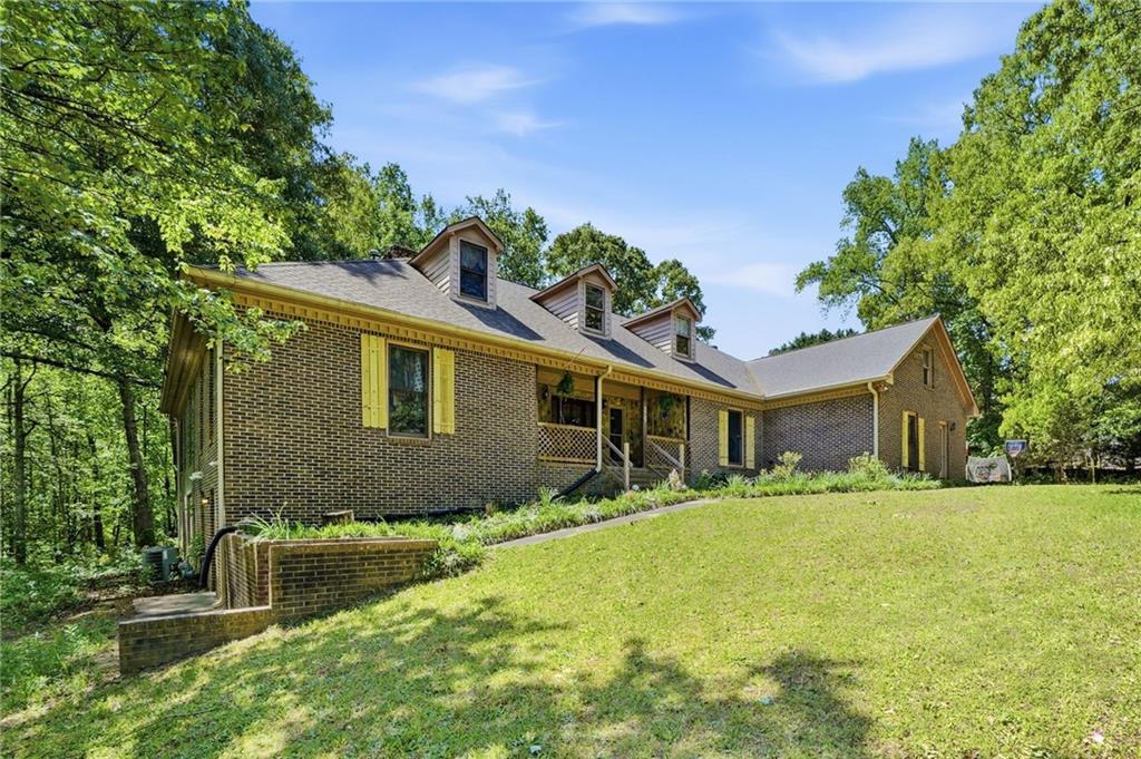 2737 John Petree Road Powder Springs, GA 30127 - Photo 4 of 55 a front view of house with yard and trees in the background