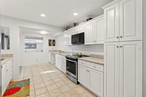 a large kitchen with stainless steel appliances granite countertop a sink and dishwasher a stove top oven with wooden floor