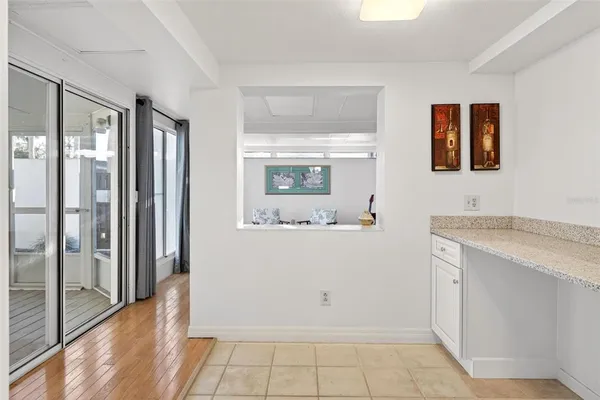 a living room with furniture a large window and wooden floor