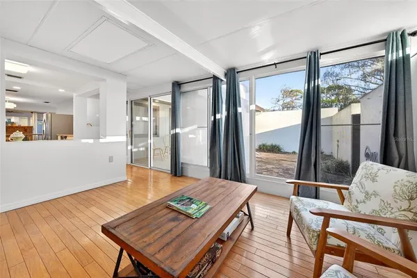 a living room with a piano and wooden floor