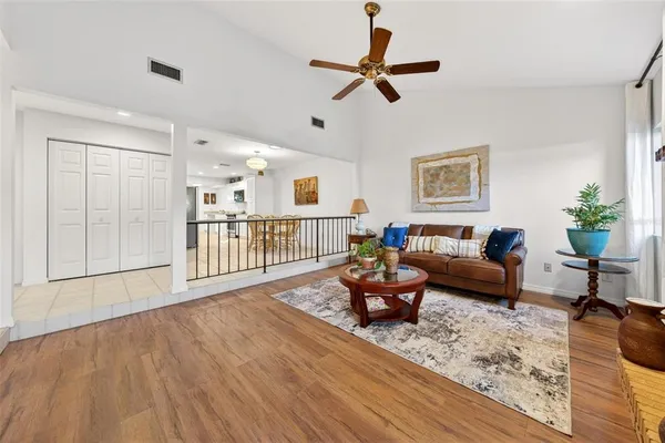 a living room with furniture stairs and a wooden floor