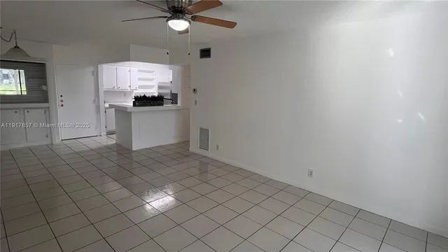 an empty room with wooden floor and a ceiling fan