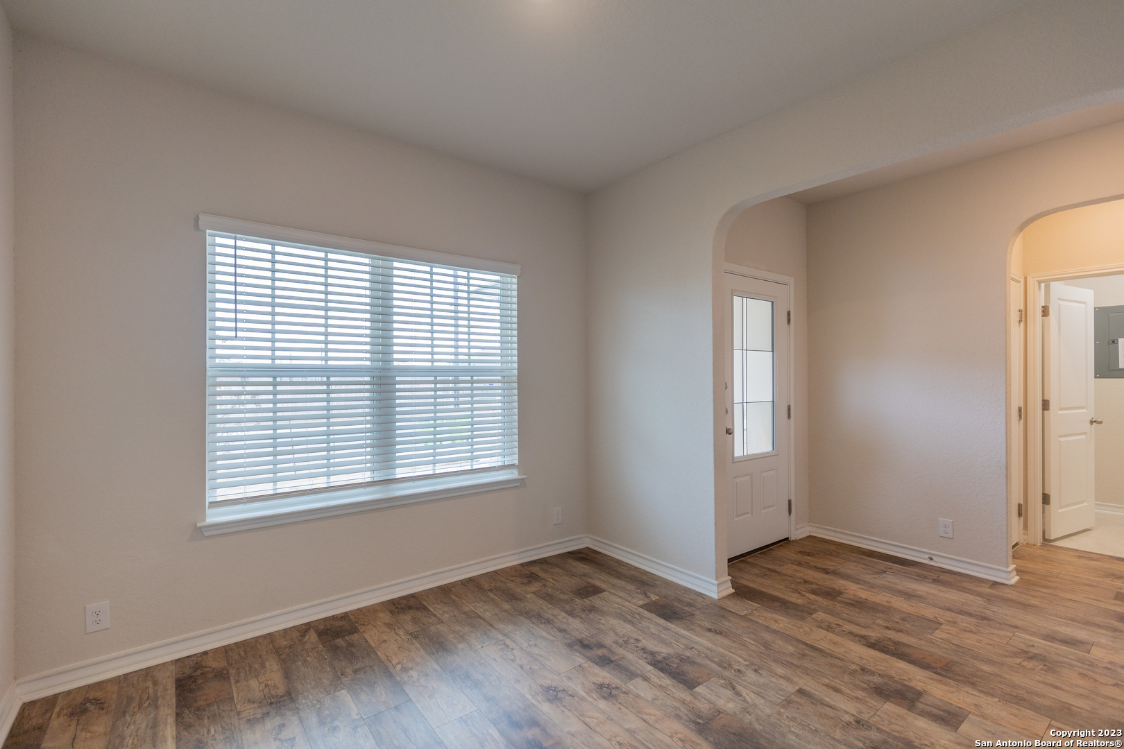 9819 Bratten Rise San Antonio, TX 78254 - Photo 5 of 37 a view of an empty room with wooden floor and a window