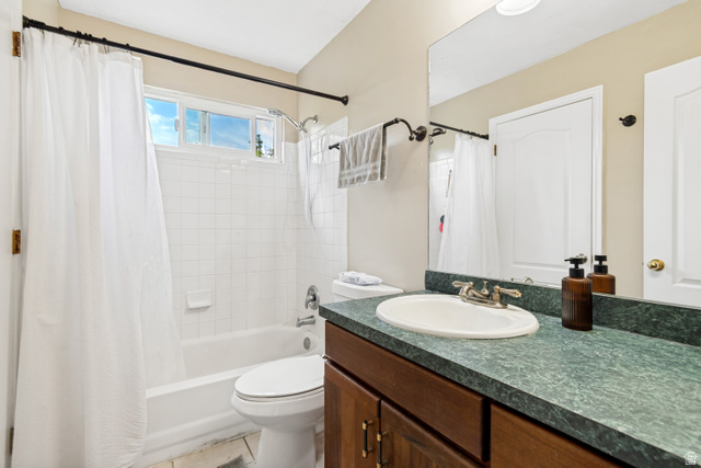 843 Deer Flat Road Tooele, UT 84074 - Photo 15 of 27 Bathroom featuring a single vanity with an integrated sink, a deep green countertop, and a wood-finish cabinet