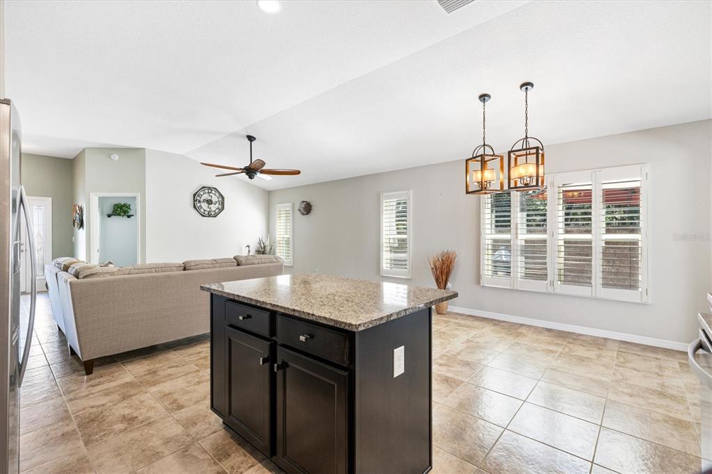 7351 Southeast 169th Cote Loop The Villages, FL 32162 - Photo 13 of 32 a kitchen with granite countertop a sink and a stove