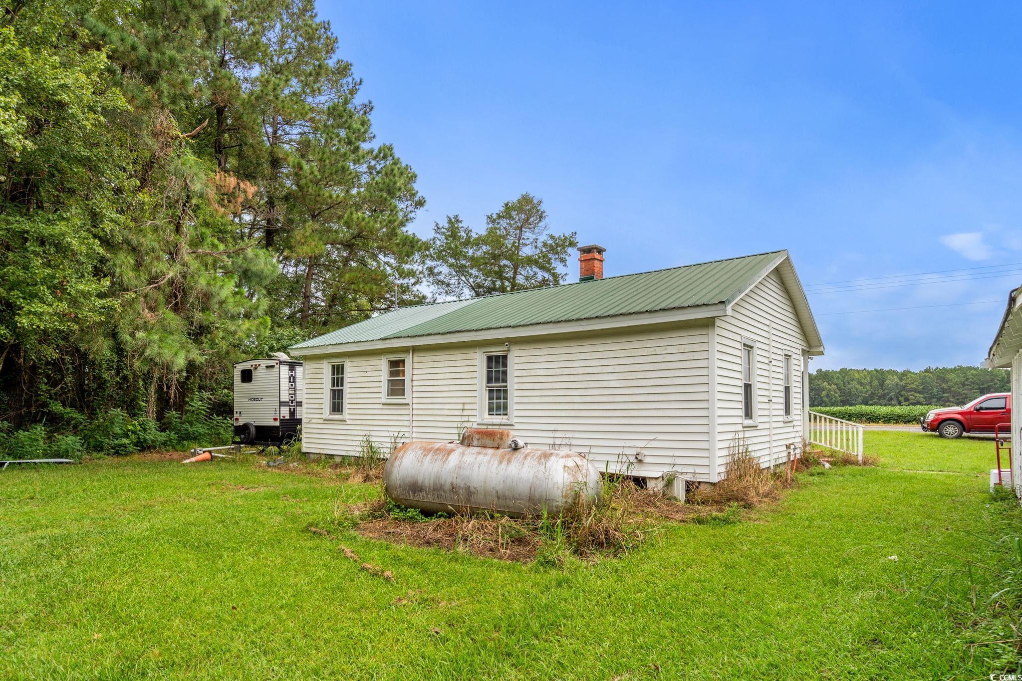 2475 Beverly Road Conway, SC 29527 - Photo 23 of 34 Rear view of house featuring a chimney, a lawn, and a metal roof