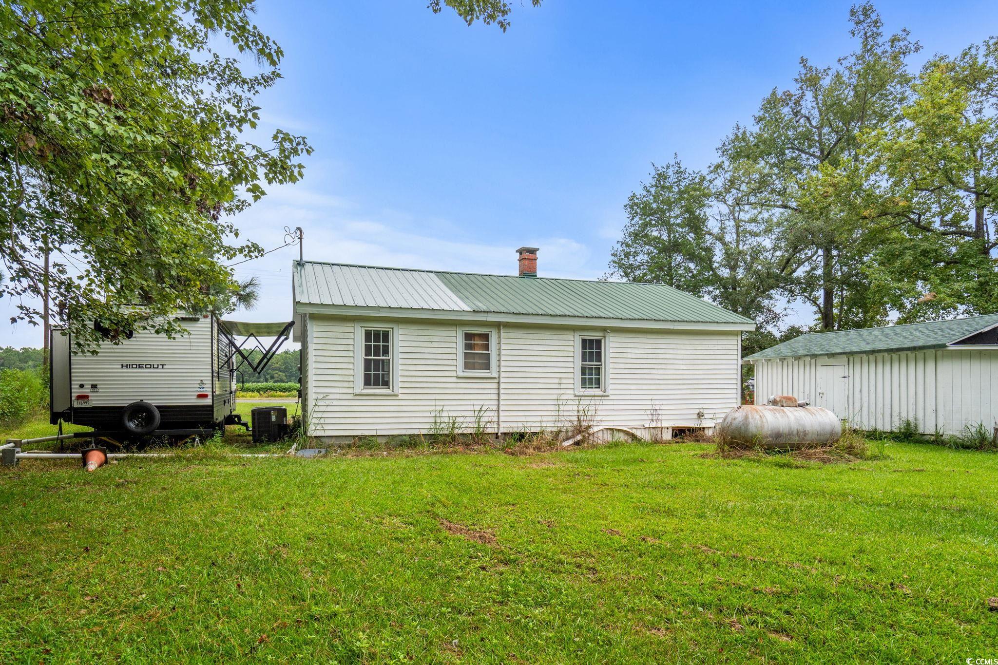 2475 Beverly Road Conway, SC 29527 - Photo 30 of 34 Rear view of house with a metal roof, a chimney, and a yard