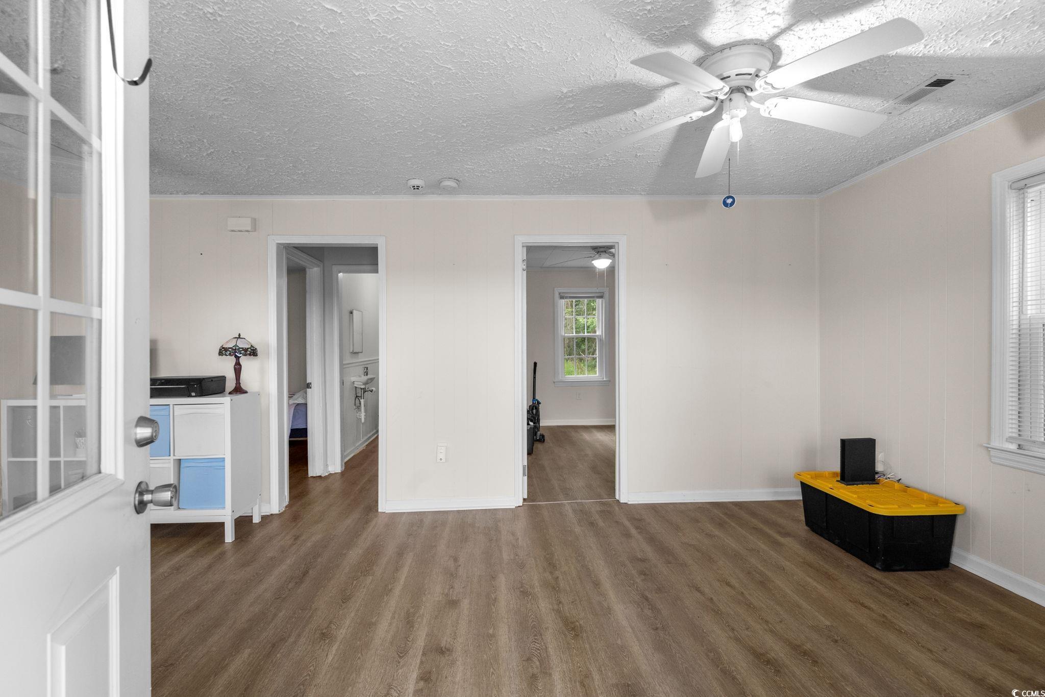 2475 Beverly Road Conway, SC 29527 - Photo 9 of 34 Unfurnished living room with wood finished floors, a textured ceiling, and ornamental molding