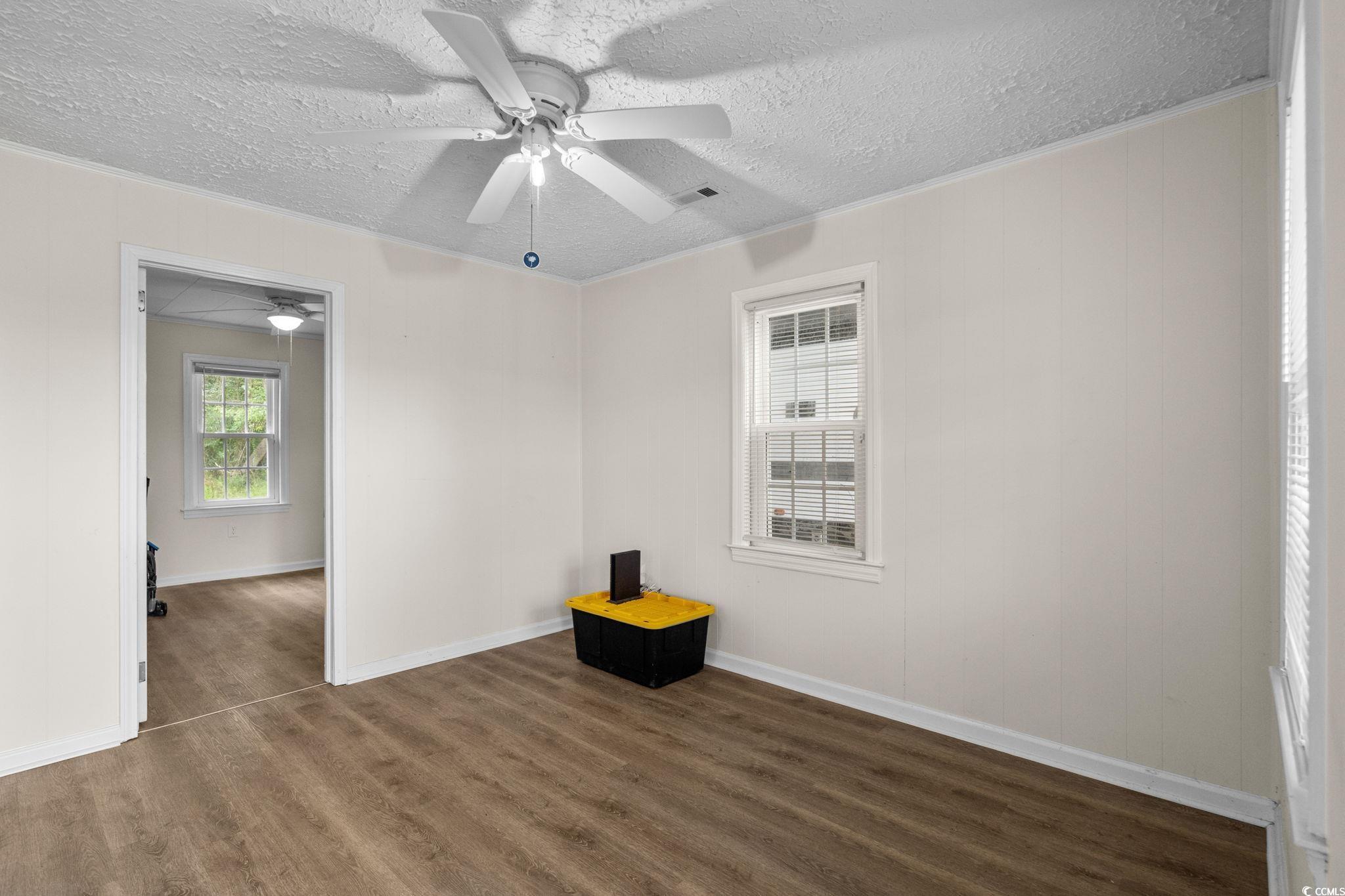 2475 Beverly Road Conway, SC 29527 - Photo 10 of 34 Empty room featuring crown molding, dark wood-style flooring, and a textured ceiling