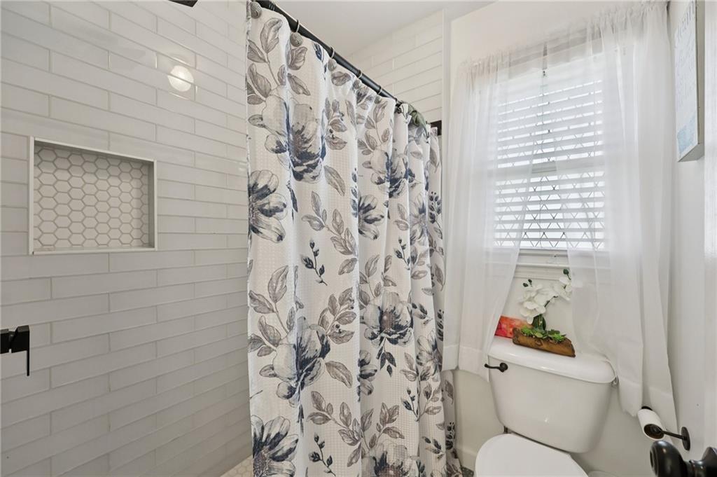704 Highland Ridge Pointe Lawrenceville, GA 30045 - Photo 24 of 36 a bathroom with a toilet and a shower curtain