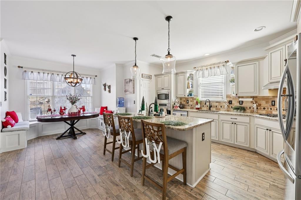 704 Highland Ridge Pointe Lawrenceville, GA 30045 - Photo 8 of 36 a living room with stainless steel appliances kitchen island granite countertop furniture and a wooden floor