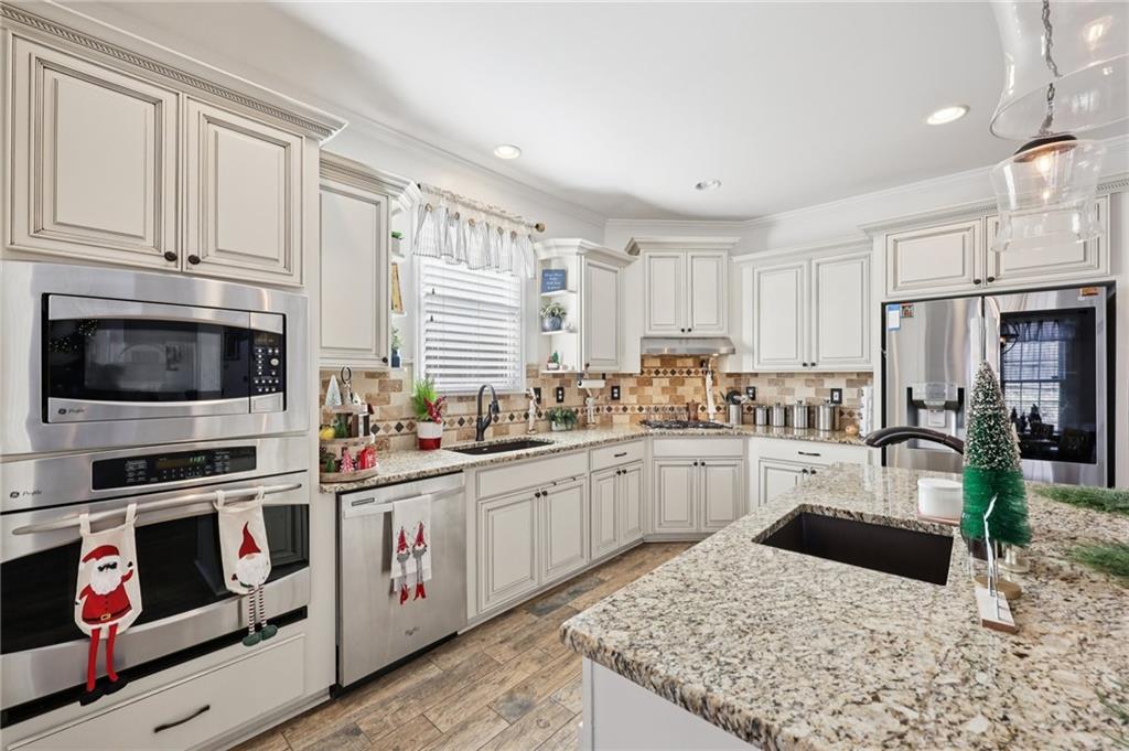 704 Highland Ridge Pointe Lawrenceville, GA 30045 - Photo 9 of 36 a kitchen with stainless steel appliances kitchen island granite countertop a stove sink and cabinets
