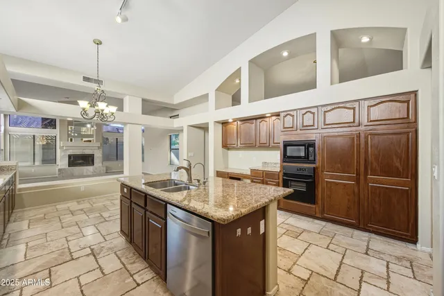 a kitchen with stainless steel appliances granite countertop a sink and a refrigerator