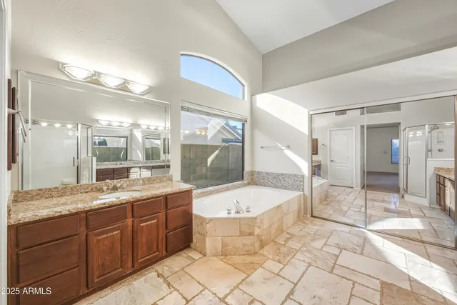 a large bathroom with a granite countertop tub a double vanity sink and a mirror