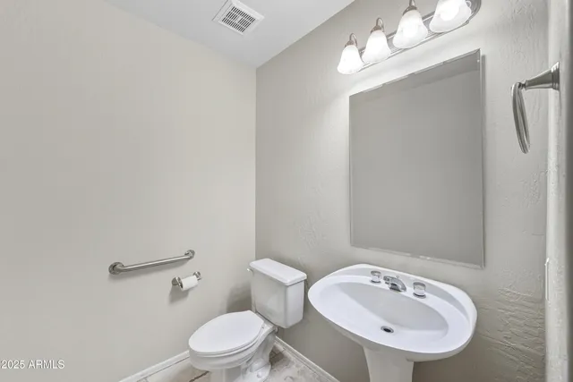 a bathroom with a sink a toilet and mirror