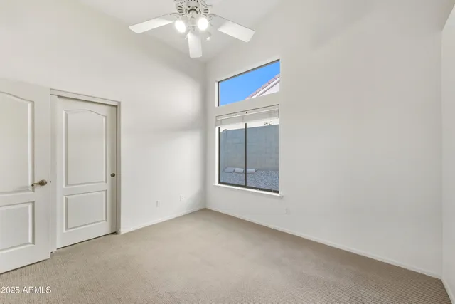 an empty room with chandelier fan