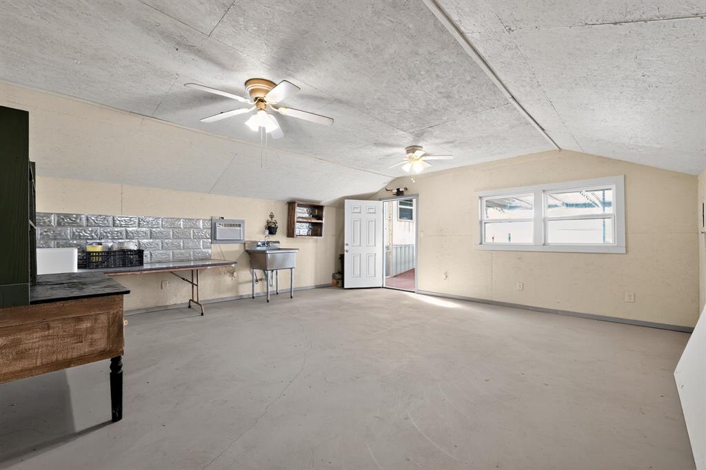 5485 Highway 7 Marlin, TX 76661 - Photo 12 of 36 Living area with lofted ceiling, a ceiling fan, unfinished concrete floors, and a wall mounted air conditioner