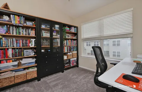 a view of a workspace with furniture and a bookshelf