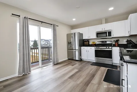 a kitchen with stainless steel appliances a stove top oven a refrigerator a sink and a microwave