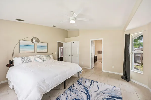 a bedroom with a large bed and a chandelier