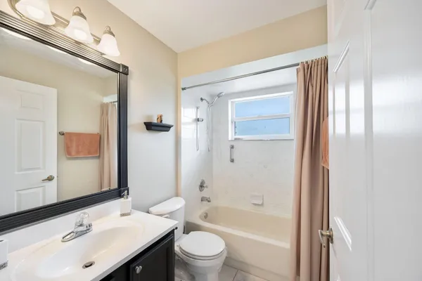 a bathroom with a bathtub shower sink vanity and toilet