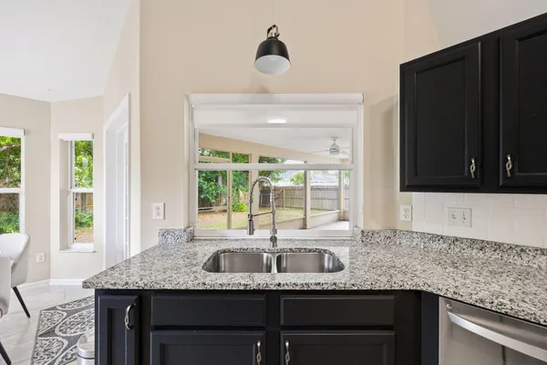 a kitchen with granite countertop a sink and a large window