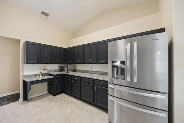 a kitchen with stainless steel appliances granite countertop a refrigerator and a sink