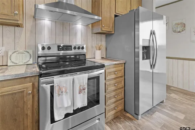 a kitchen with stainless steel appliances granite countertop a refrigerator and a stove