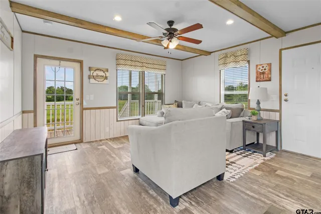 a living room with furniture and a large window with wooden floor